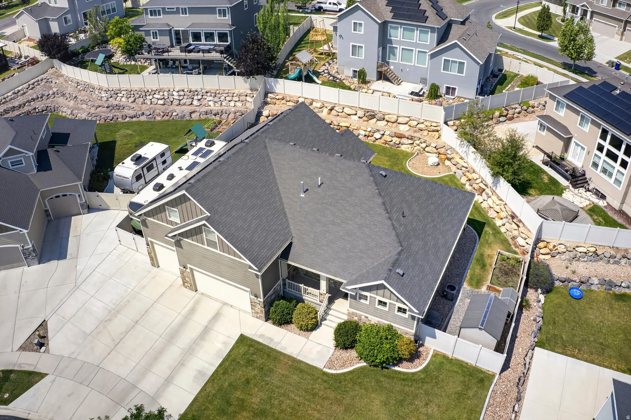 Aerial perspective showcasing a residential property with a multi-car driveway and a well-maintained lawn