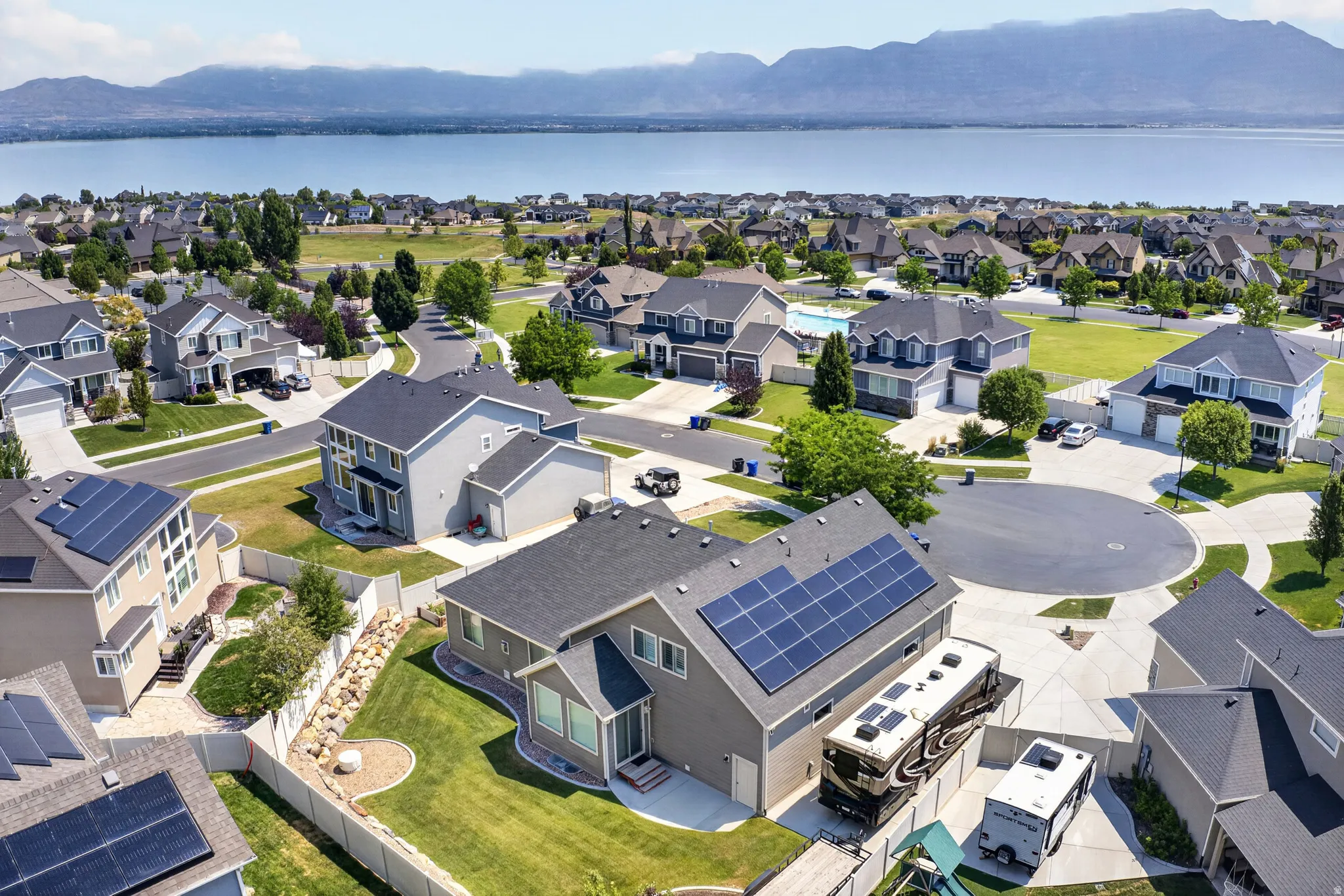 Aerial perspective showcasing a residential area with a prominent body of water and distant mountains