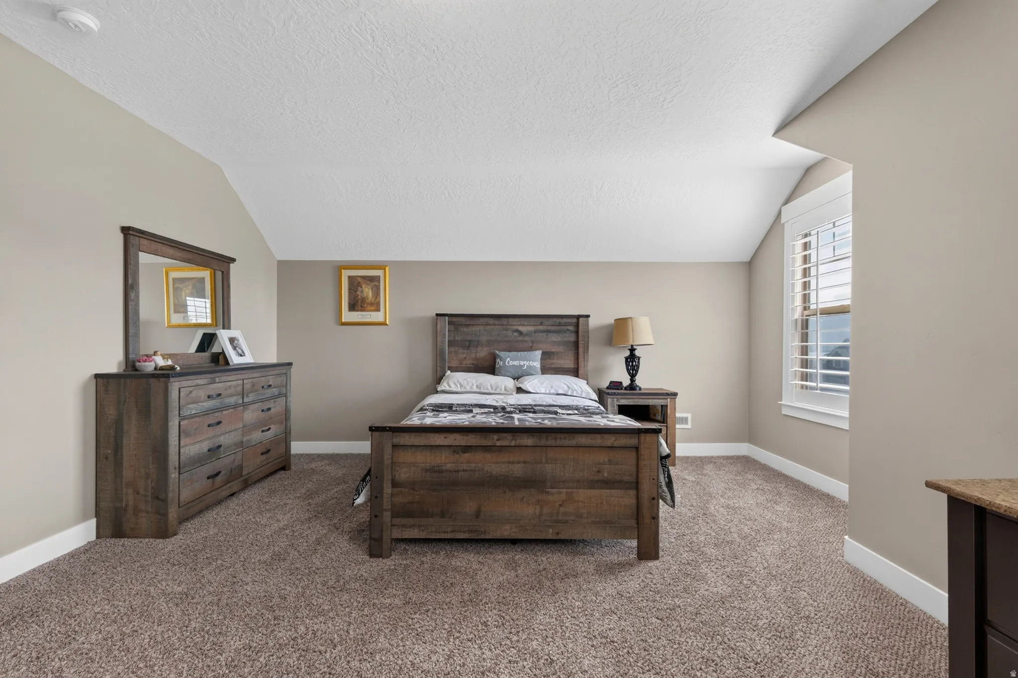 Carpeted room featuring a window with plantation shutters, neutral wall tones, and white baseboards