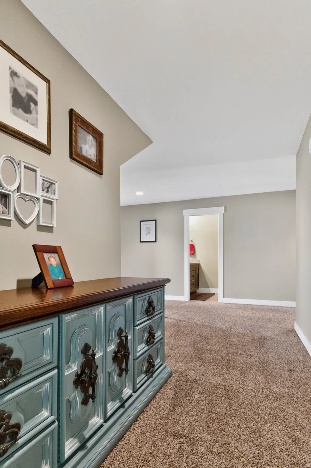 Carpeted hallway with neutral wall paint and white baseboards