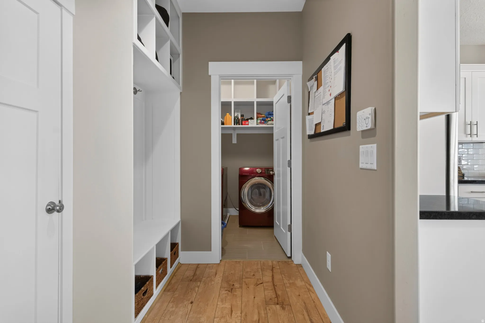 Mudroom featuring built-in white cabinetry with open shelving and storage cubbies