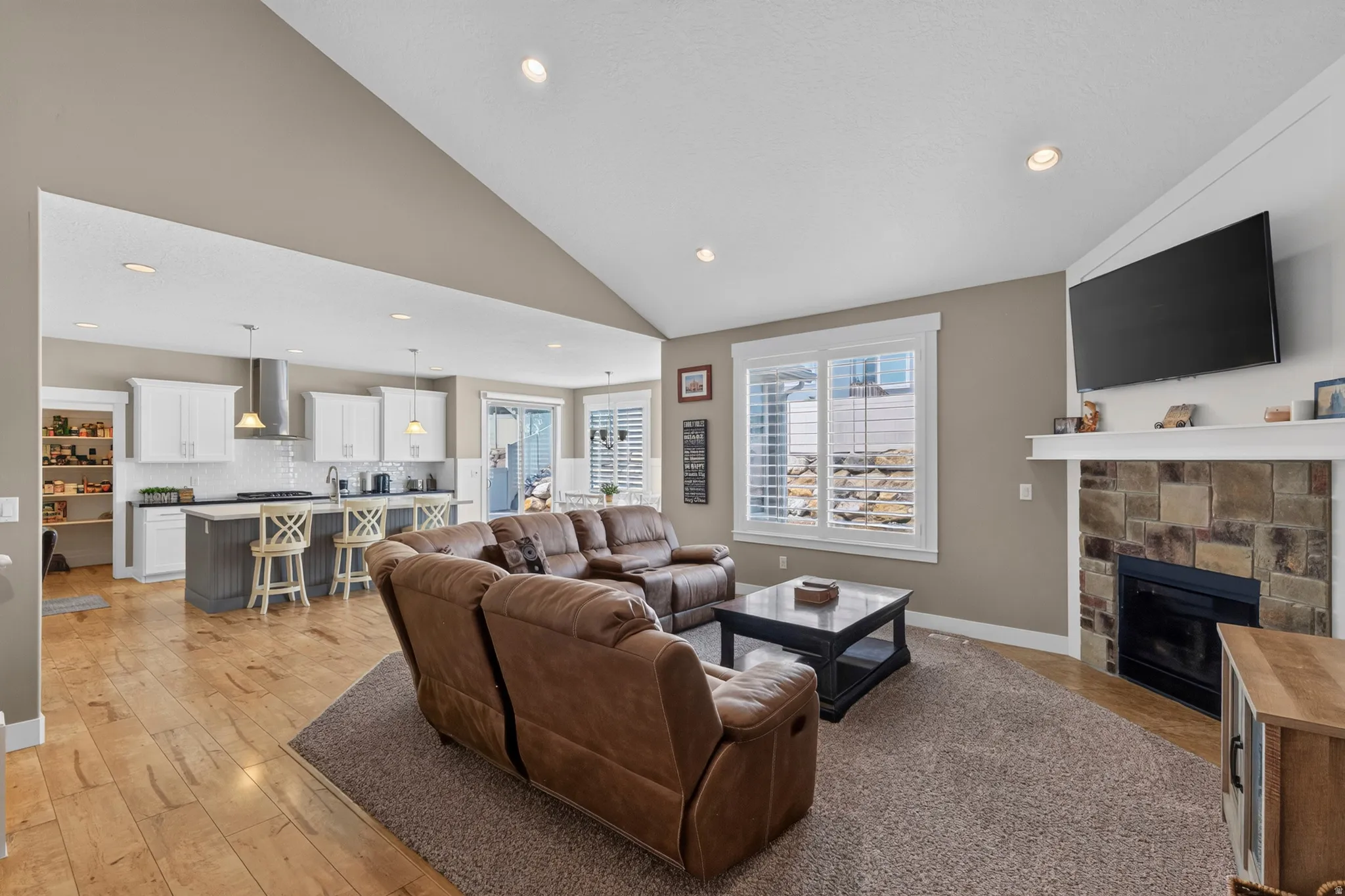 Expansive living area with vaulted ceilings and recessed lighting