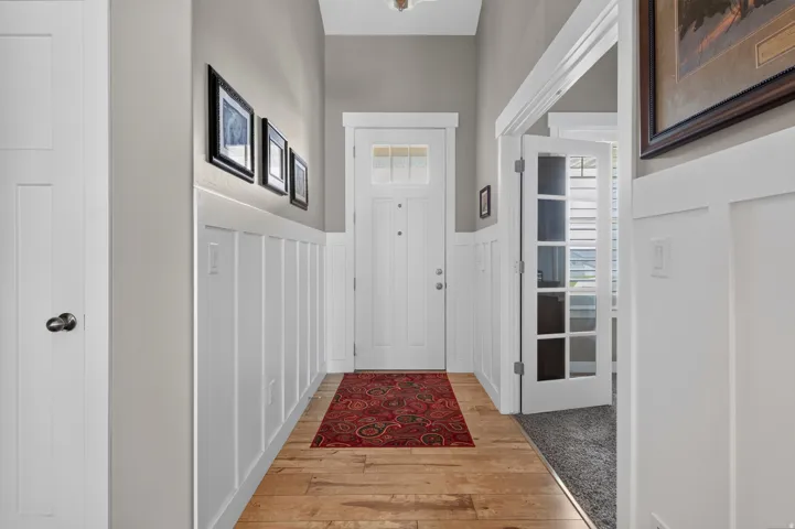 Entryway featuring wood-finish flooring, white board and batten paneling, and a door with an integrated window