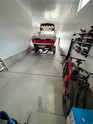 Extended garage bay featuring a concrete floor, painted walls, and overhead lighting