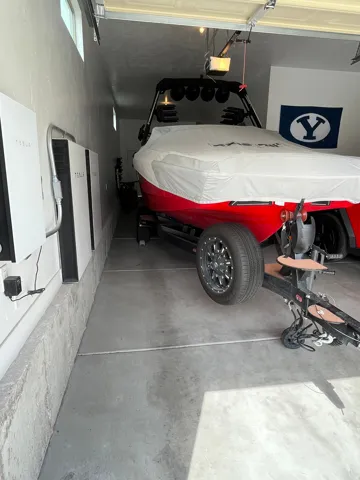 Garage interior featuring concrete flooring and Tesla Powerwall battery storage units