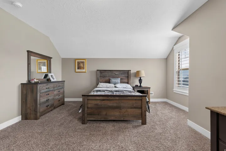 Carpeted room featuring a window with plantation shutters, neutral wall tones, and white baseboards