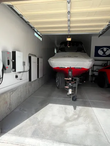 Spacious garage featuring concrete flooring and a partial concrete wall