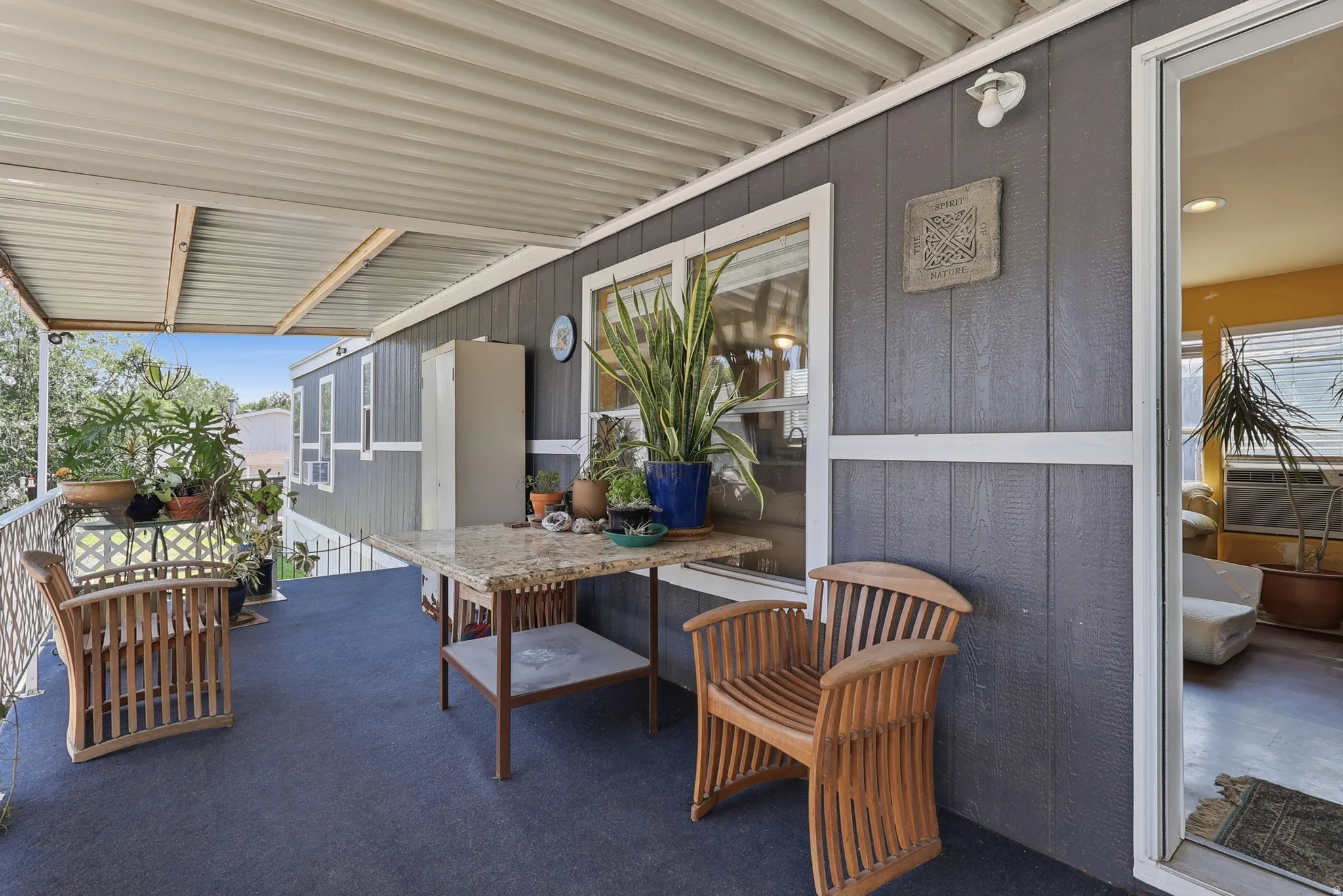 Expansive covered porch featuring a corrugated metal roof and dark gray siding