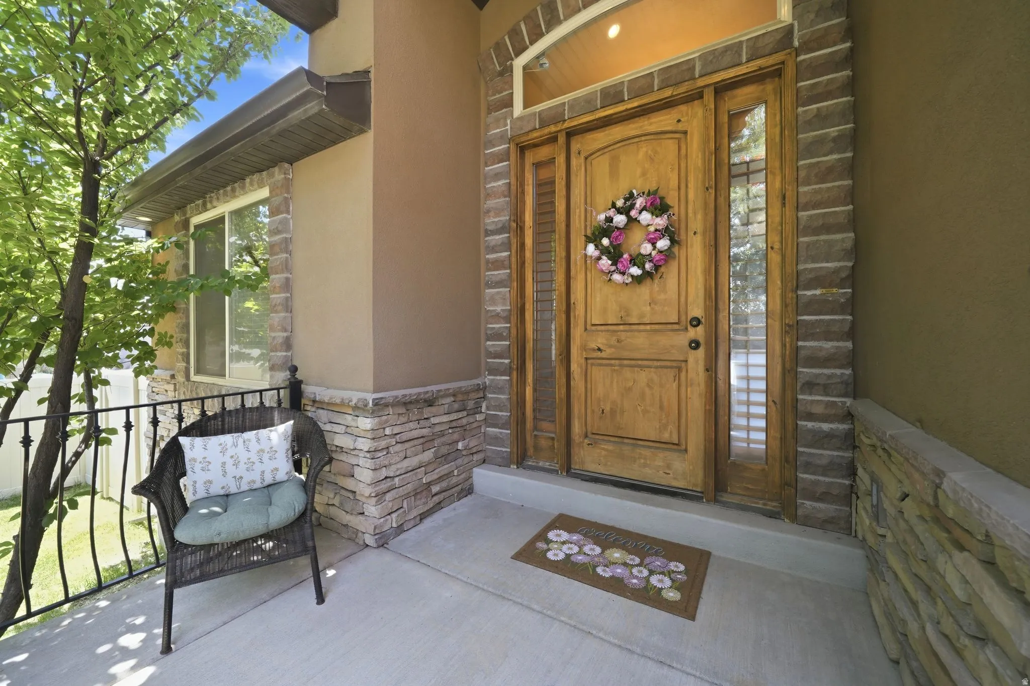 Front Porch featuring a solid wood door with sidelights, transom window, and stacked stone accents