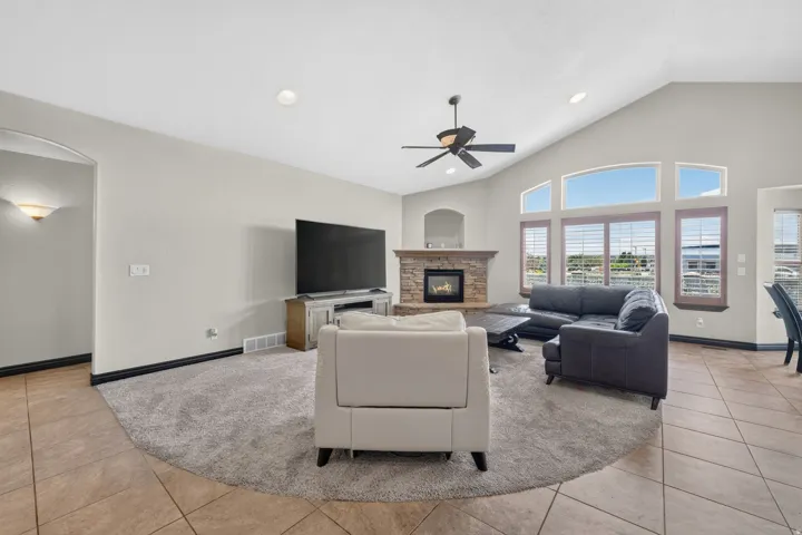 Living area with a vaulted ceiling, recessed lighting, and a ceiling fan