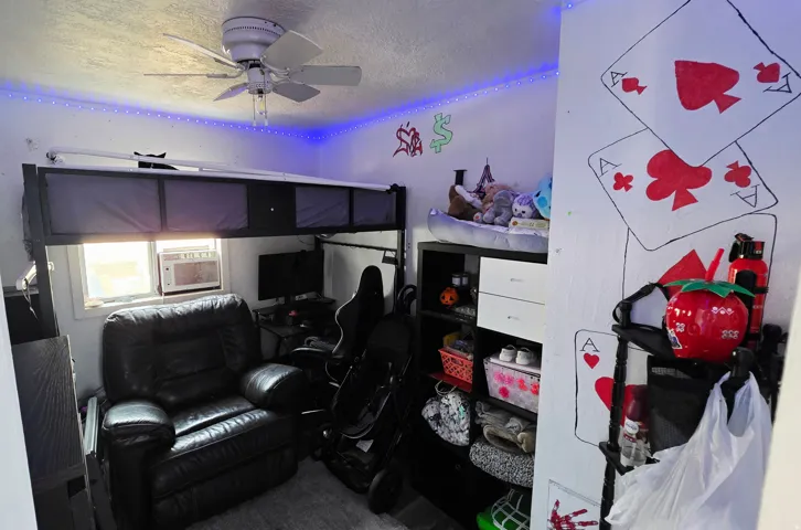 Room featuring a ceiling fan with integrated lighting, a window, and a built-in loft bed frame