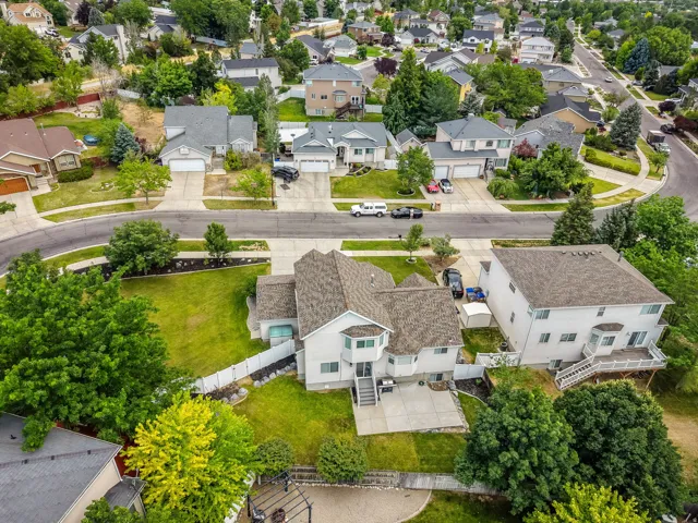 Spacious suburban property with a multi-level exterior, featuring a private fenced yard, mature trees, and a concrete patio