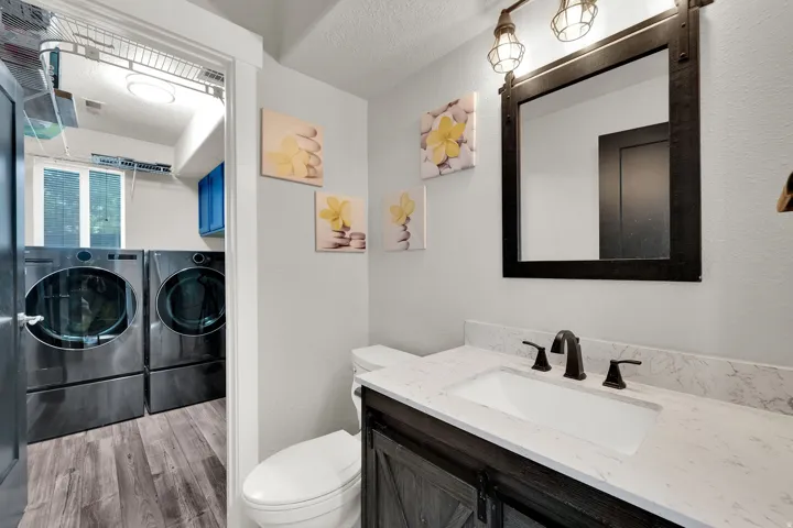 Bathroom vanity with a white rectangular undermount sink, black faucet, and a granite countertop