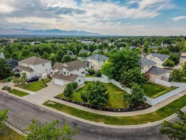 Corner lot residence featuring a two-car garage, established landscaping, and a fenced backyard