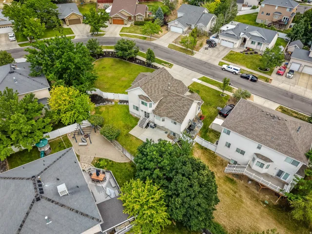 Two-story residence with a light-colored exterior and a brown shingle roof
