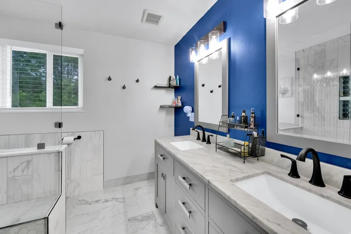 Dual vanity featuring undermount sinks, granite  countertops, and matte black fixtures