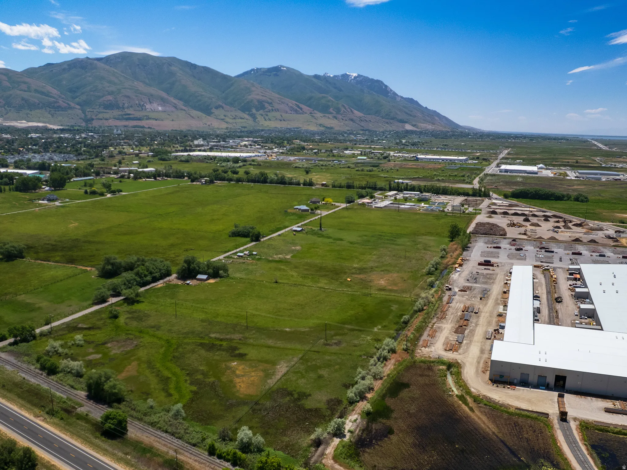 Expansive green fields with distant mountains under a clear sky