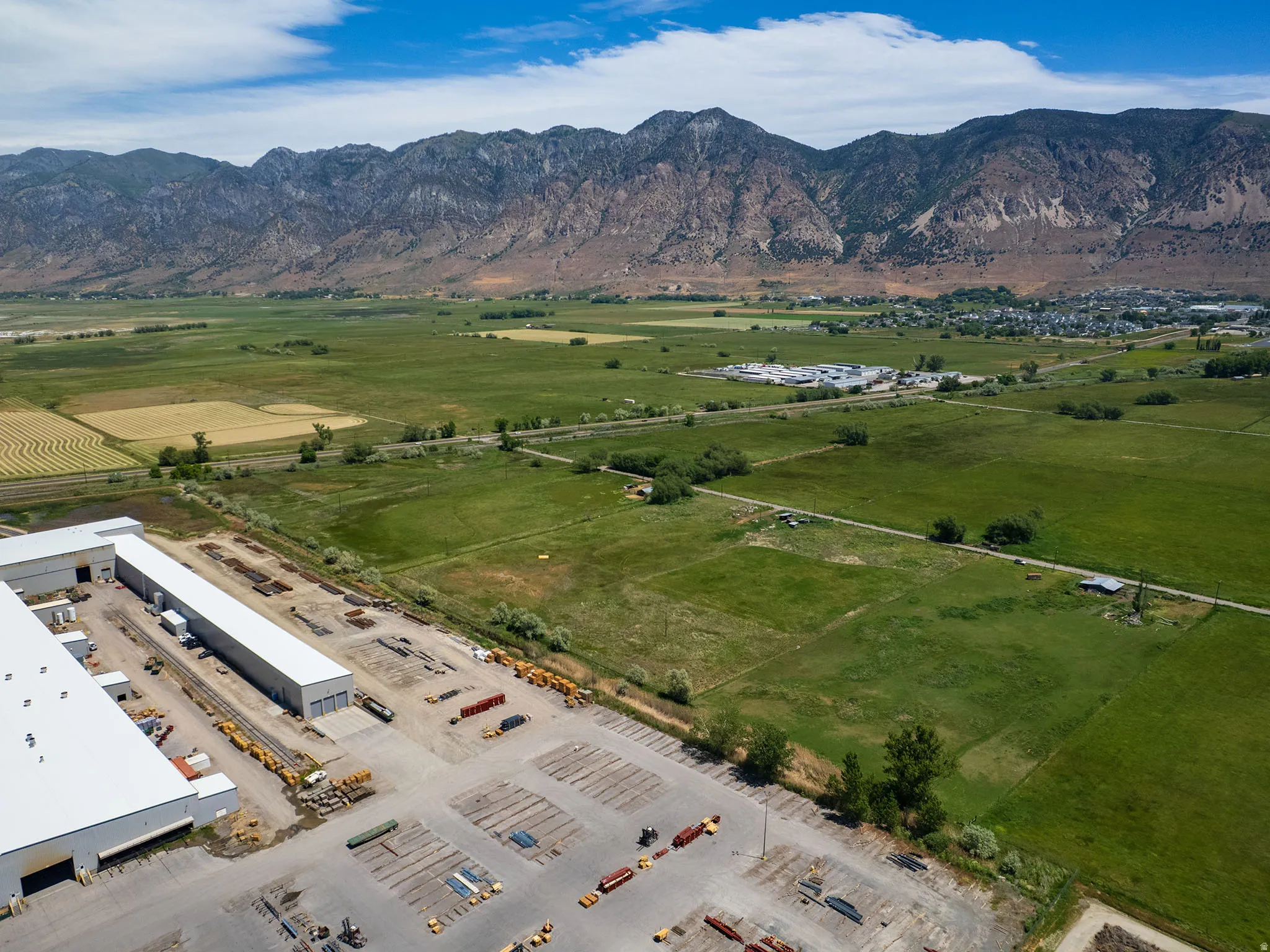 Expansive industrial complex featuring multiple large warehouses with white roofs and extensive paved parking areas
