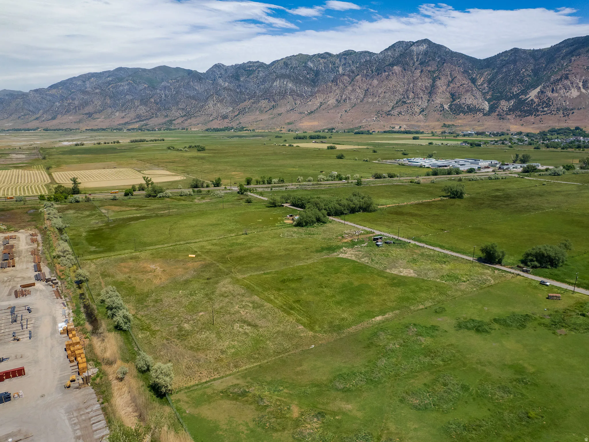 Expansive land parcel featuring verdant fields and distant mountain terrain
