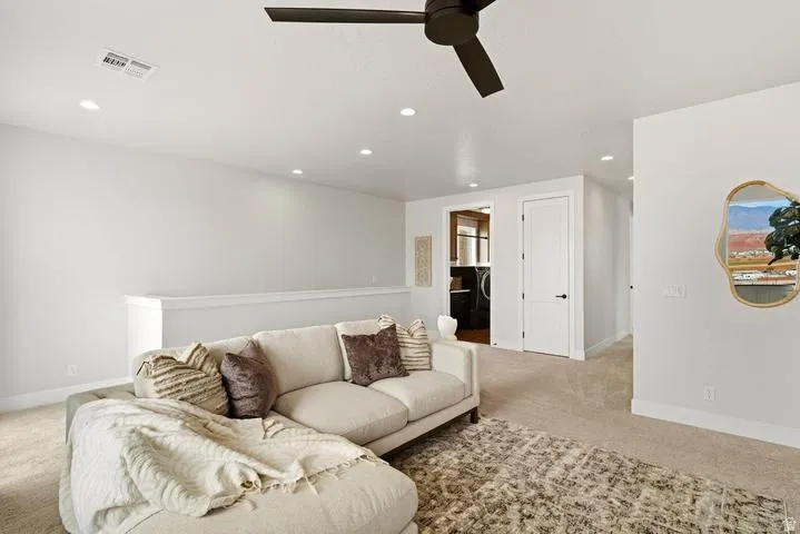 Spacious room featuring neutral carpeting, recessed lighting, and a modern ceiling fan