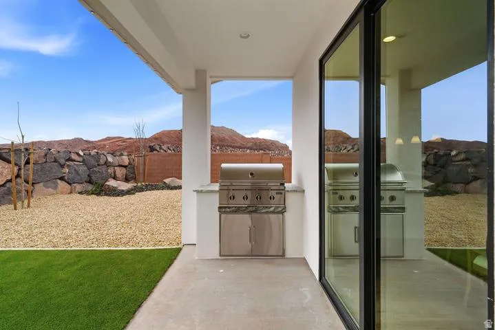 Covered patio with an integrated stainless steel grill and a light-colored countertop
