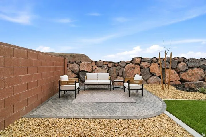 Outdoor paver patio with a curved edge, surrounded by gravel landscaping