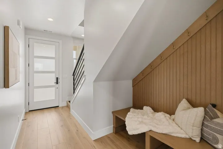 Entryway featuring wood-finish flooring, a modern front door with frosted glass panels, and recessed lighting