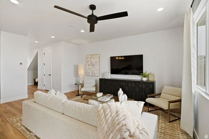 Open-concept living space with wood-finish flooring, recessed lighting, and a modern ceiling fan