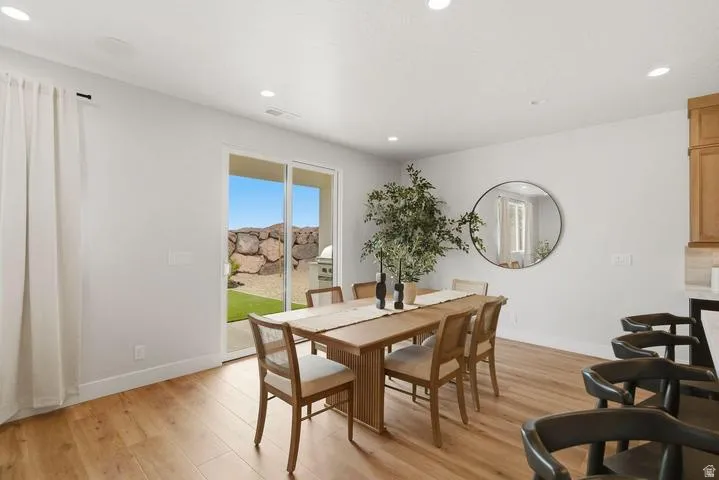 Dining area with wood-finish flooring, recessed lighting, and a sliding glass door opening to the exterior