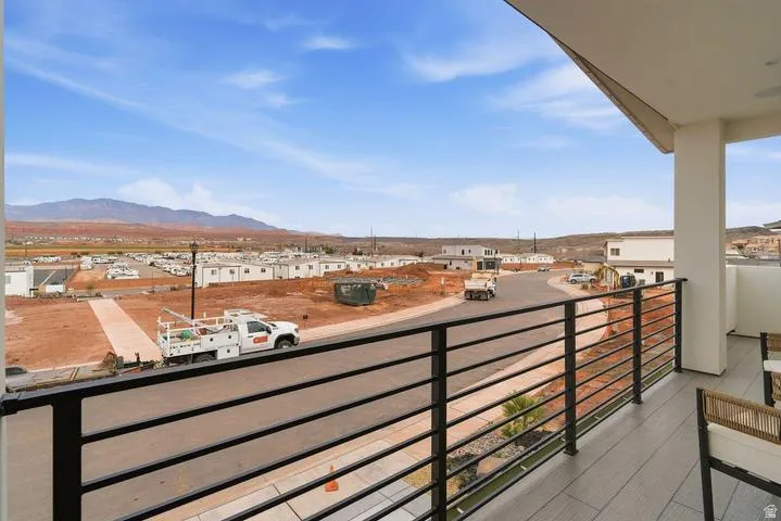 Expansive outdoor balcony featuring contemporary black horizontal railings and wood-finish tile flooring