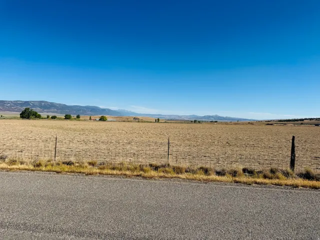 Expansive open fields with distant mountain ranges and a clear blue sky