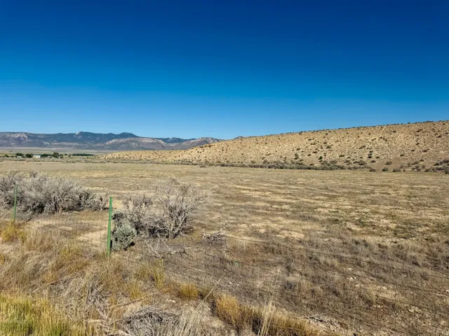 Expansive land parcel featuring natural desert vegetation and distant mountain ranges