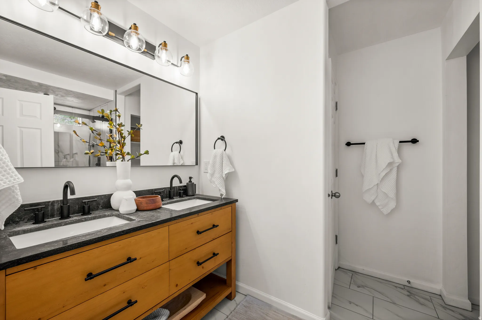 Double vanity with a dark stone countertop and integrated white sinks