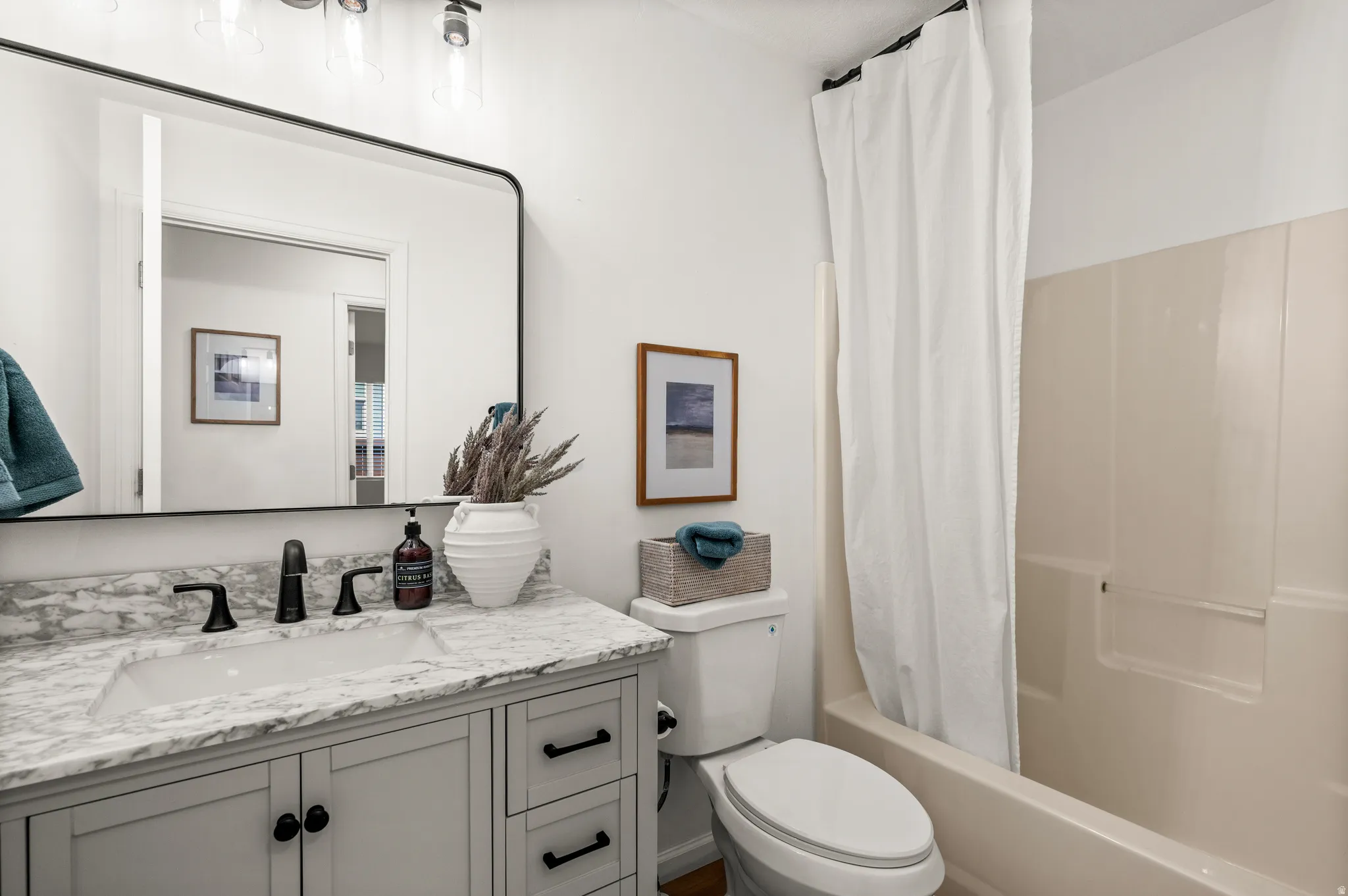 Bathroom vanity featuring a rectangular undermount sink, marble-patterned countertop, and matte black fixtures
