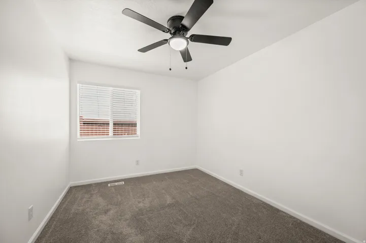 Room featuring a ceiling fan with integrated lighting, a window with horizontal blinds, neutral wall paint, and gray carpet flooring