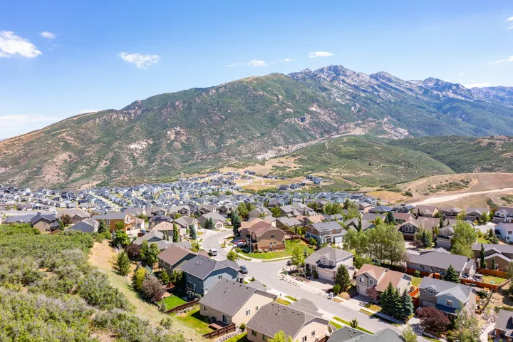 Expansive residential community featuring diverse architectural styles situated against a dramatic mountain range