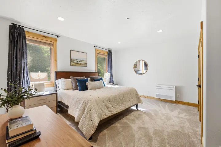 Carpeted bedroom featuring recessed lighting and natural wood window trim