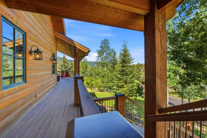 Expansive exterior deck crafted from wood planks, featuring a log-style siding