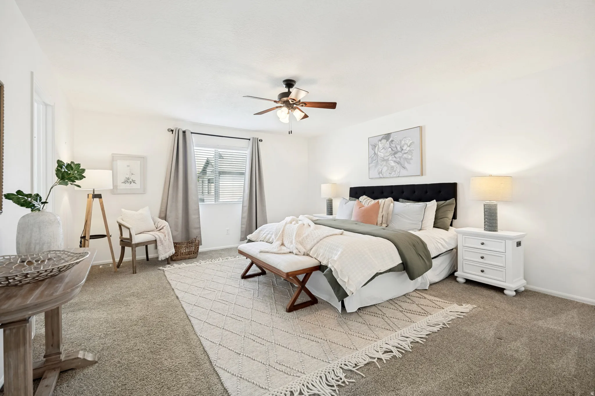 Spacious bedroom featuring neutral carpeting, a window with horizontal blinds, and a ceiling fan with integrated lighting