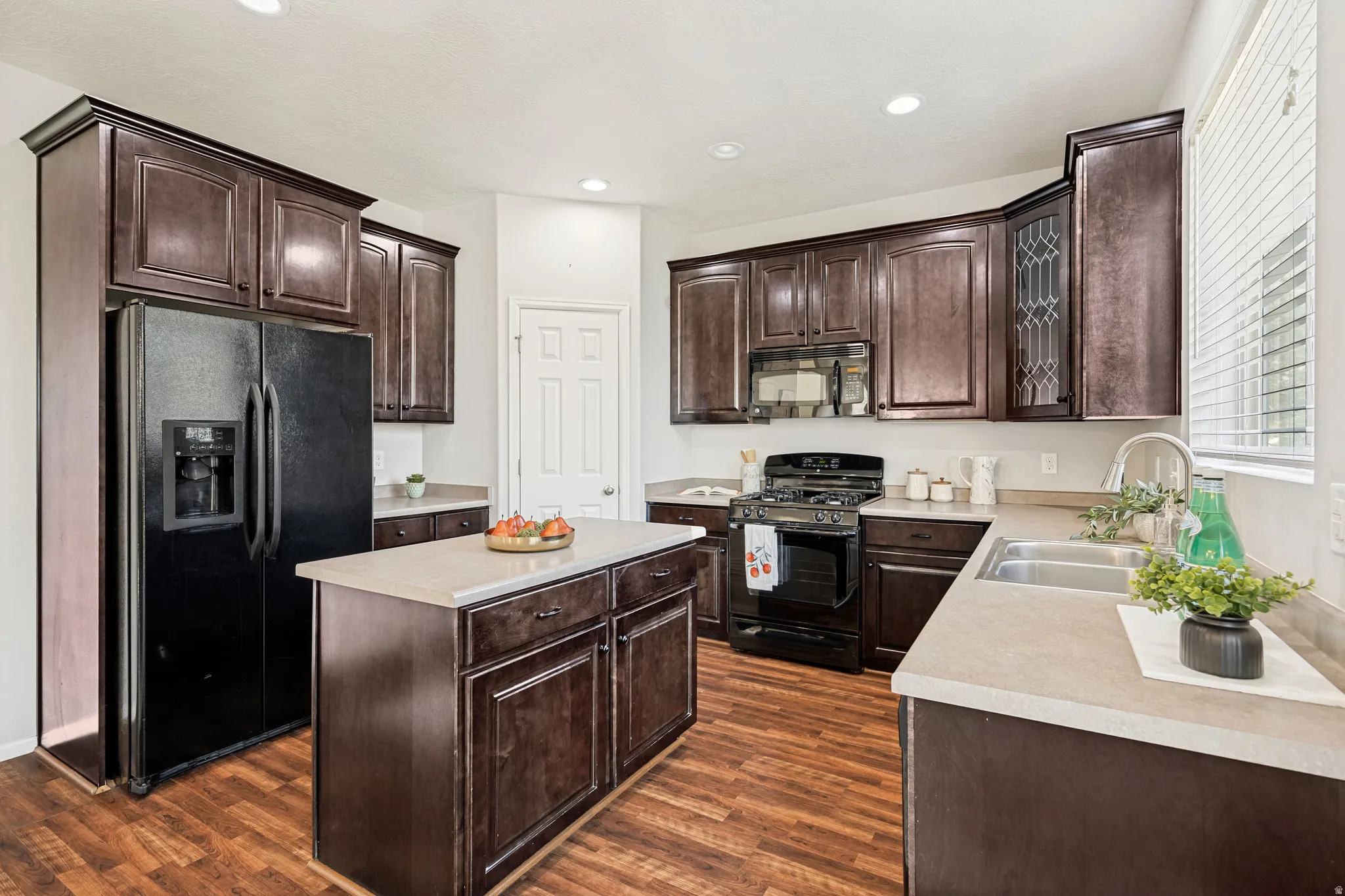 Kitchen featuring wood-finish flooring and dark wood cabinetry