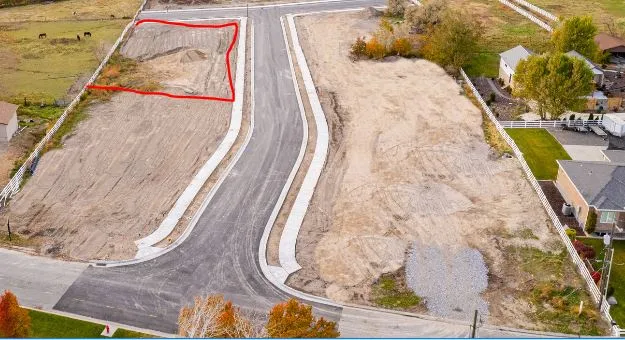 Expansive cleared lot featuring established roads and sidewalks