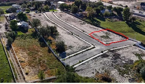 Level lot featuring direct street access, established curbing, and utility access
