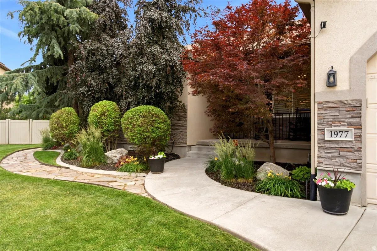 Manicured front yard with a flagstone path and concrete walkway