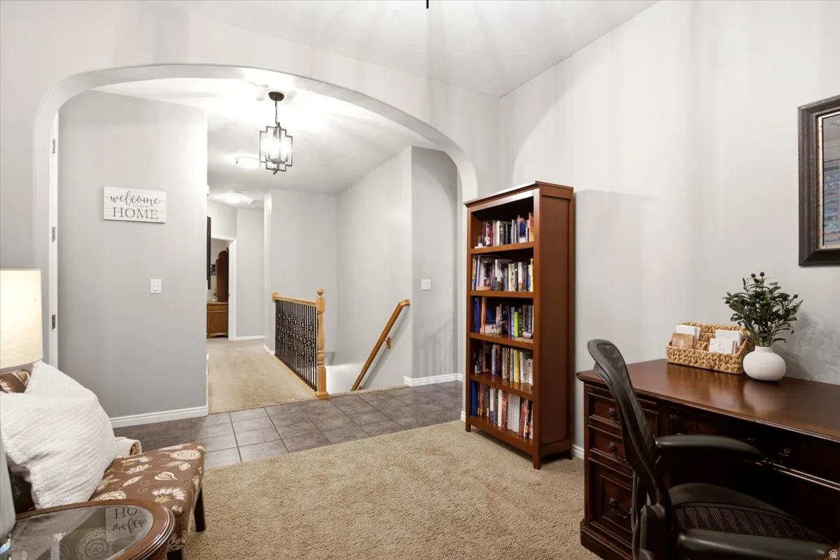 Archway entry to a bright hallway with recessed lighting
