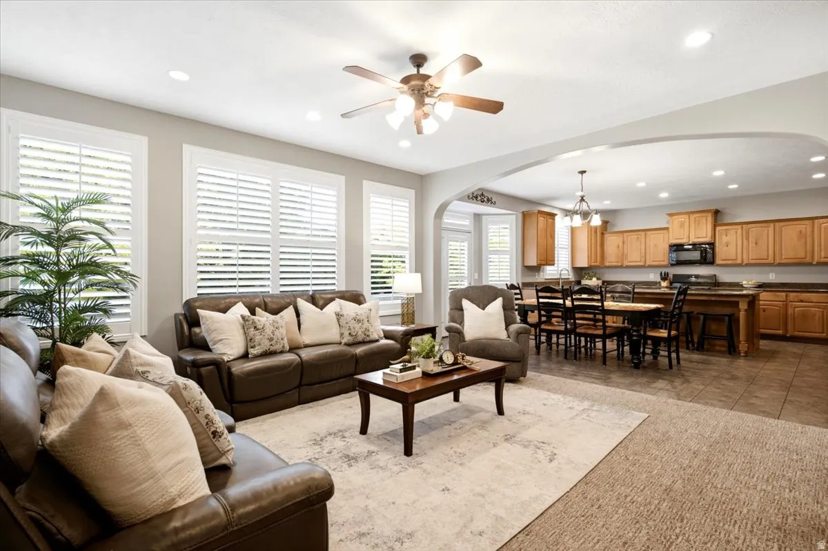 Open-concept living space featuring recessed lighting, a ceiling fan, and white plantation shutters