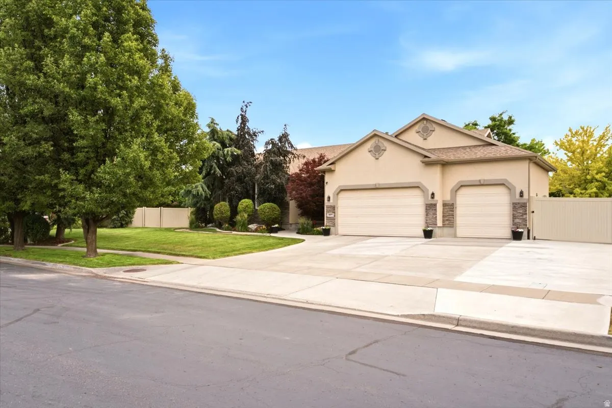 Expansive concrete driveway and two-car garage with overhead doors