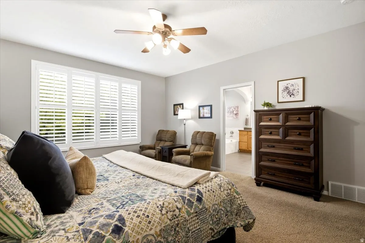 Spacious room featuring neutral wall tones and a ceiling fan