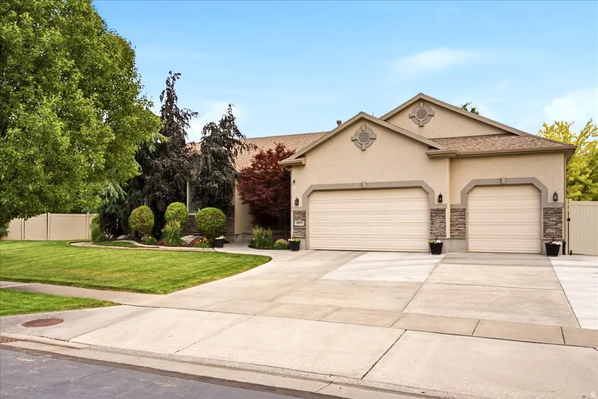 Stucco exterior with stone accents and twin garage doors