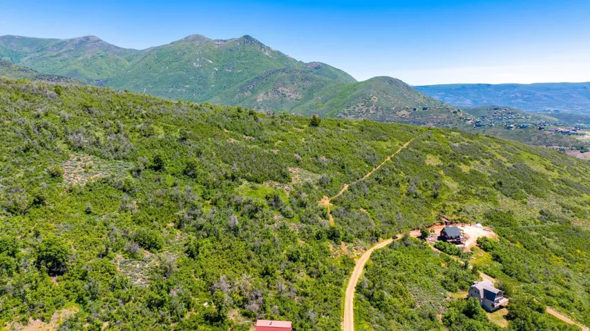 Expansive mountainous terrain with lush green vegetation under a clear blue sky
