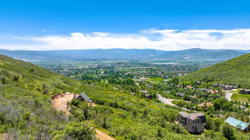 Elevated mountain setting with broad valley and distant mountain ranges